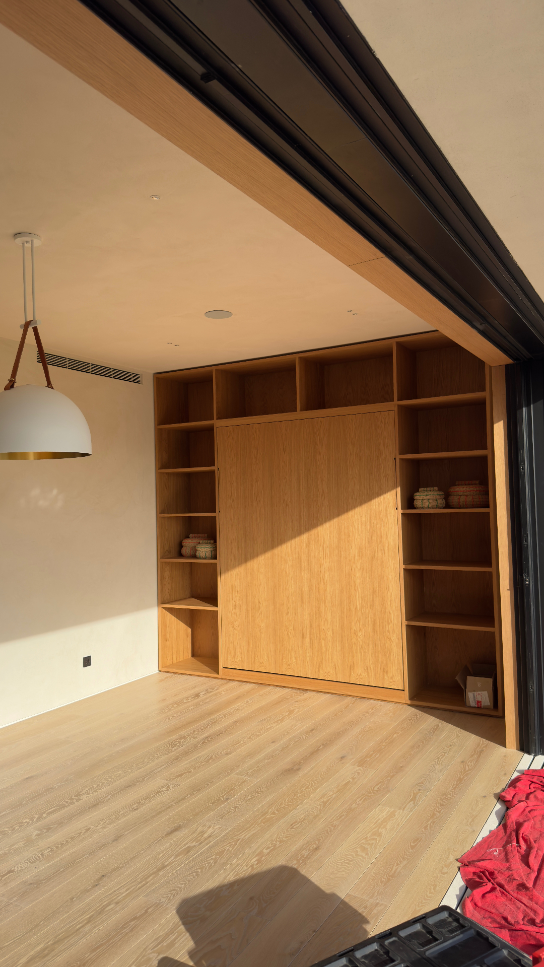 Floor-to-ceiling oak built-in with integrated murphy bed